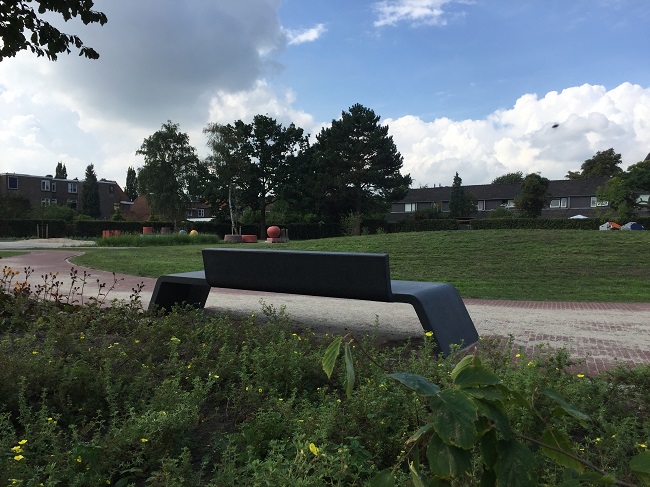 Een betonnen bankje in het parkje aan de Spechtstraat.